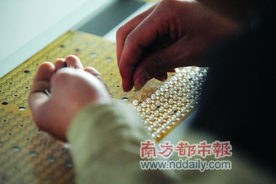 工人忙著安裝用于燈具發(fā)光的LED燈珠，這類工作處于LED燈具生產(chǎn)的最下游。資料圖